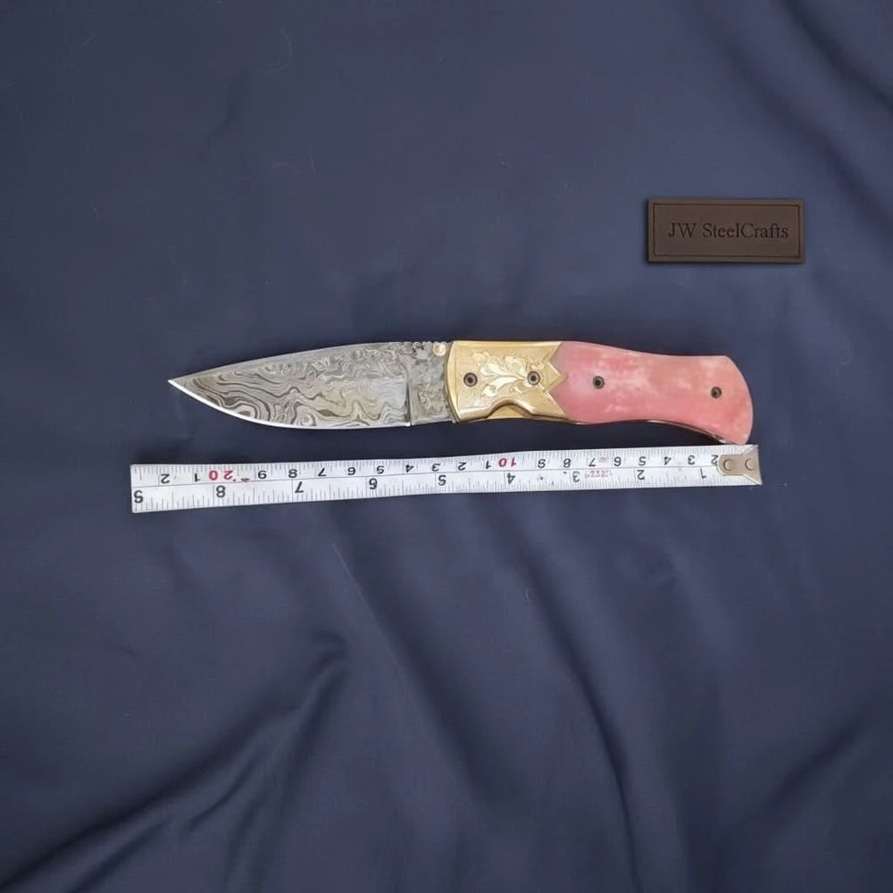     Rubyedge folding blade featuring pink handle and artistic Damascus steel pattern for outdoor everyday carry