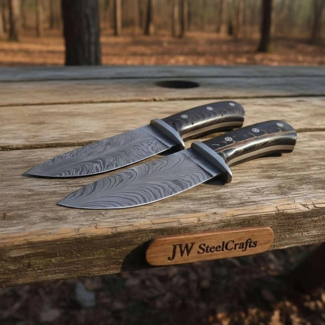 Forest stump matching Damascus knives by JW SteelCrafts with black handles and brown leather sheath.