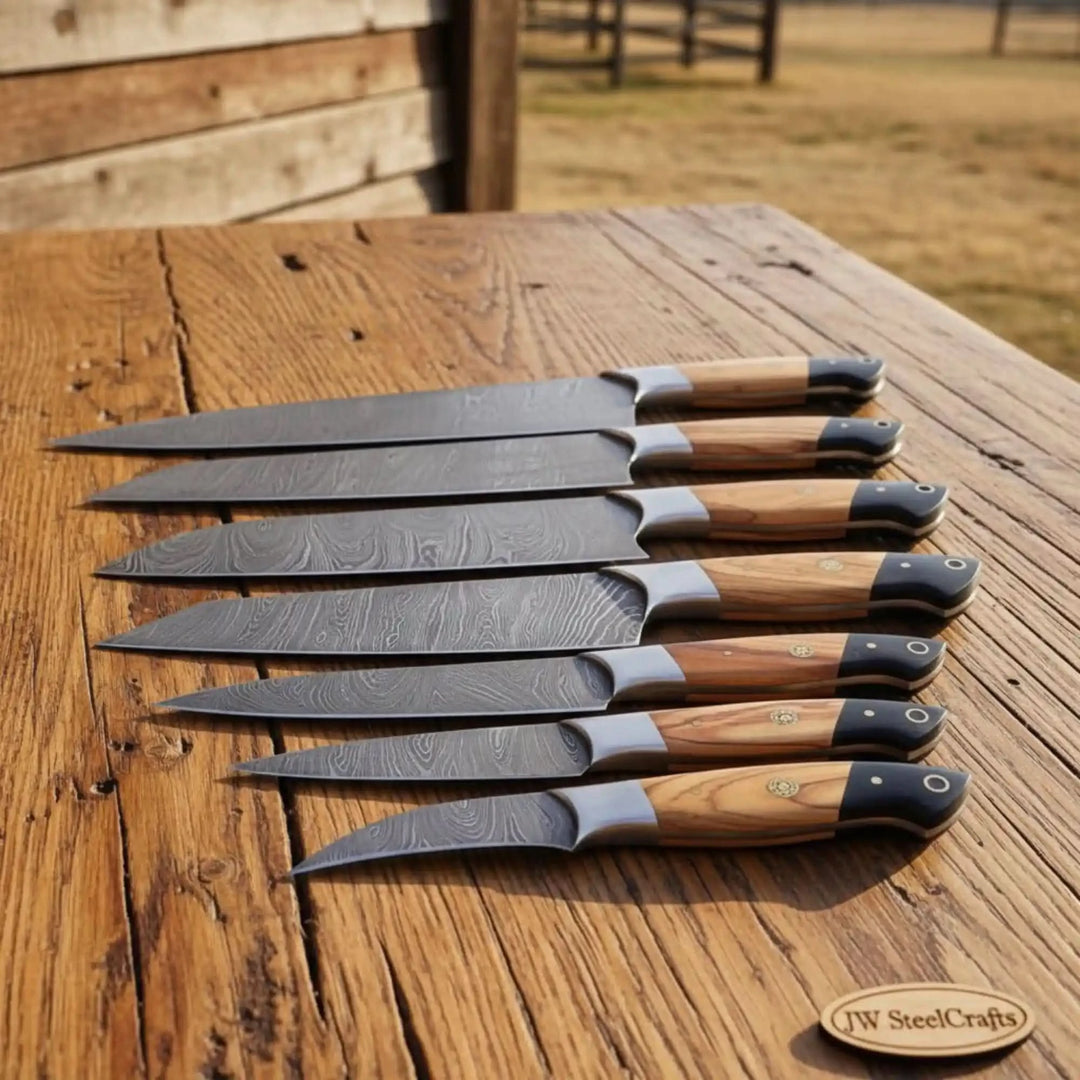 Premium Damascus precision blades displayed in side angle arrangement on wooden surface.Rustic Damascus fishing knife set with handcrafted olive wood handle craftsmanship