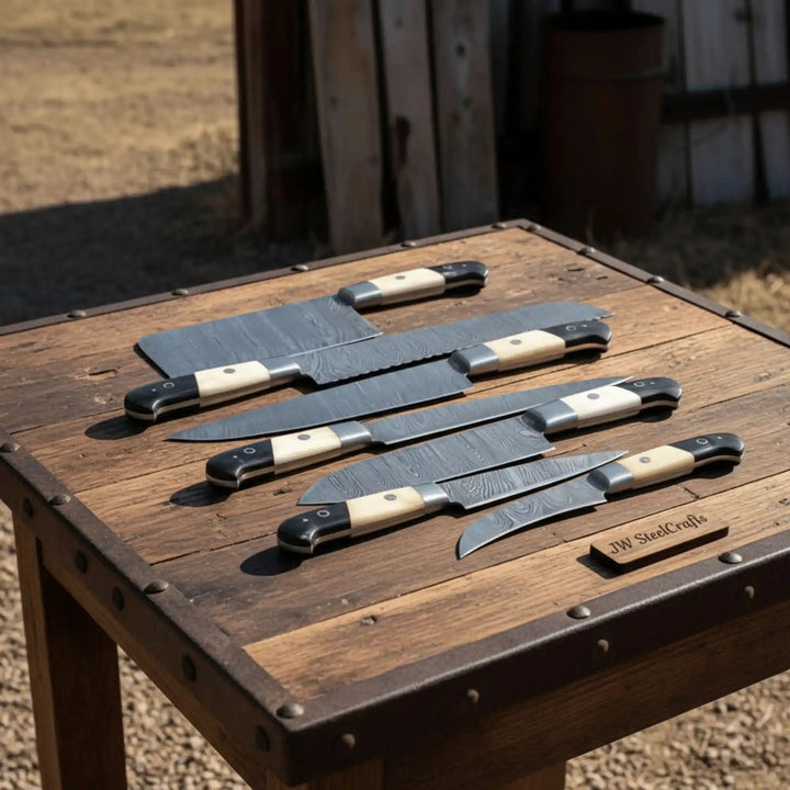 Seven Damascus steel kitchen knives arranged horizontally on white background with black and ivory two tone handles.