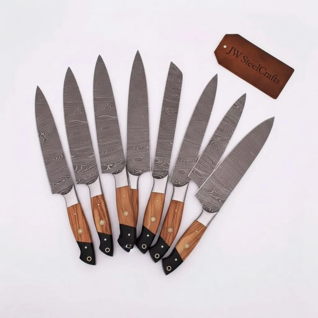 Handcrafted Damascus chef knives arranged diagonally on a white background