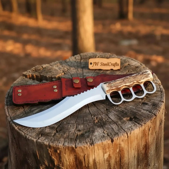 Premium Stainless Steel Hunting Knife Knife With Knuckle Duster Handle And Red Sheath On A Wooden Stump

