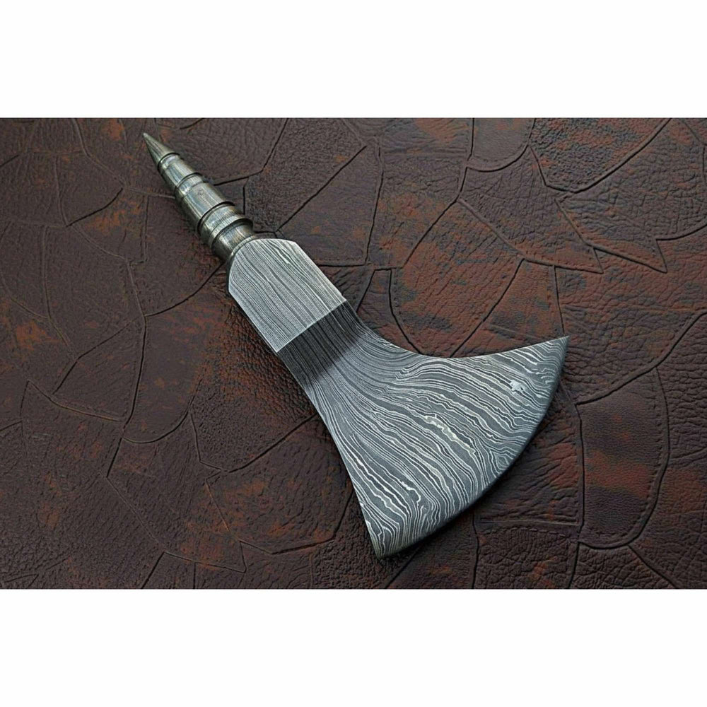     Rugged Damascus handcrafted axe with full metal construction displayed in misty forest atmosphere.
