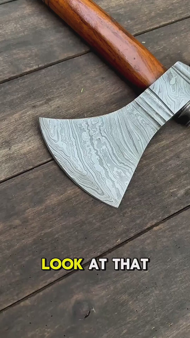 Durable Damascus bushcraft axe video featuring wide curved blade and polished natural wood handle.