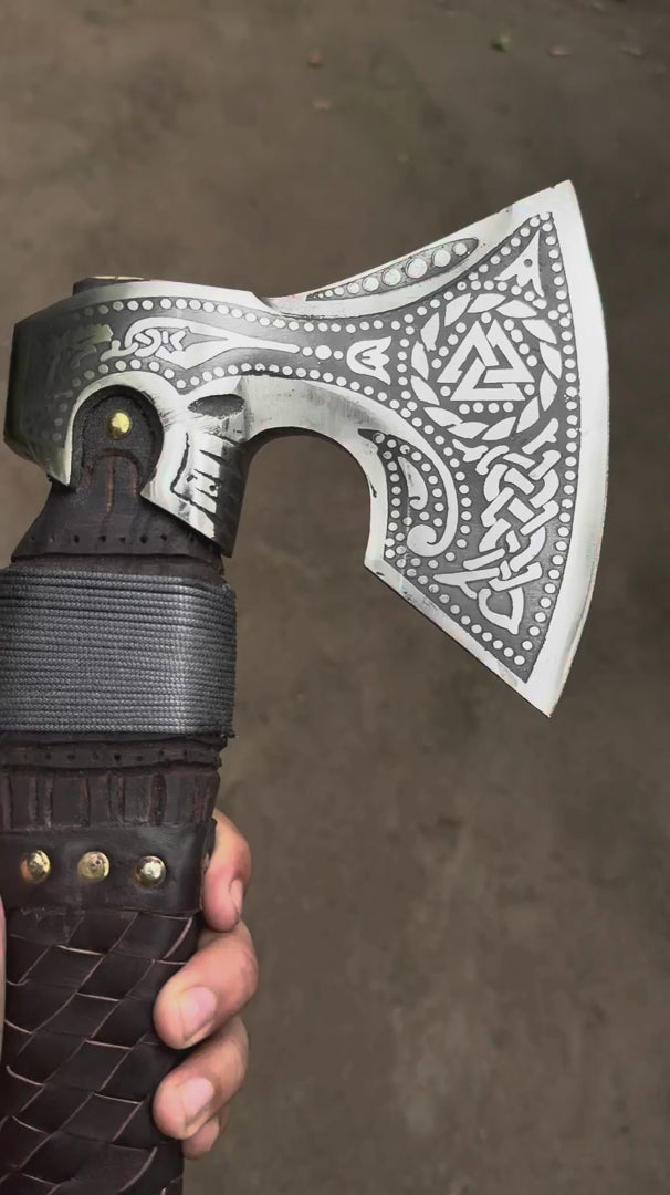 Alt Text: Demonstration video of a durable Celtic battle axe showing detailed silver carvings and dark leather craftsmanship.