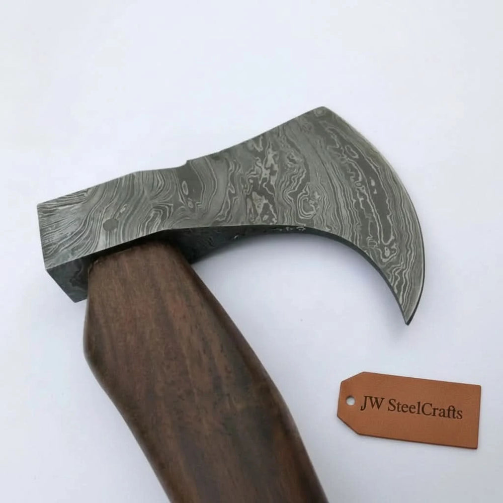 High carbon Damascus camping hatchet handmade with a polished hardwood grip and decorative steel blade ideal for bushcraft, camping, and outdoor survival use.