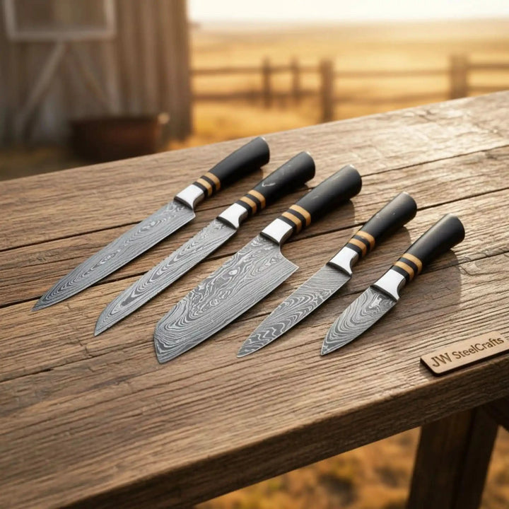Handcrafted Damascus chef knives with intricate blade wave textures displayed in a rustic outdoor setting.