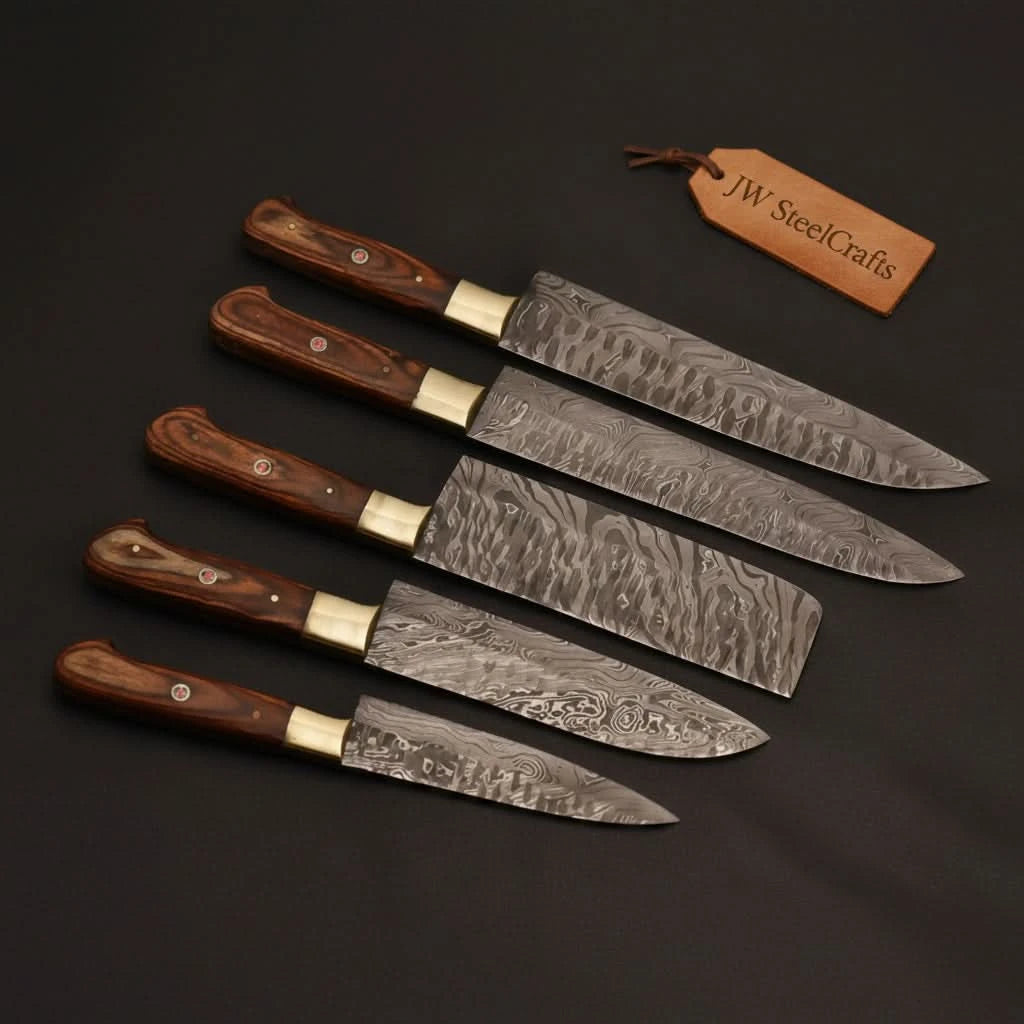 High end kitchen cutlery collection displayed on matte black backdrop with decorative layered steel blade patterns.