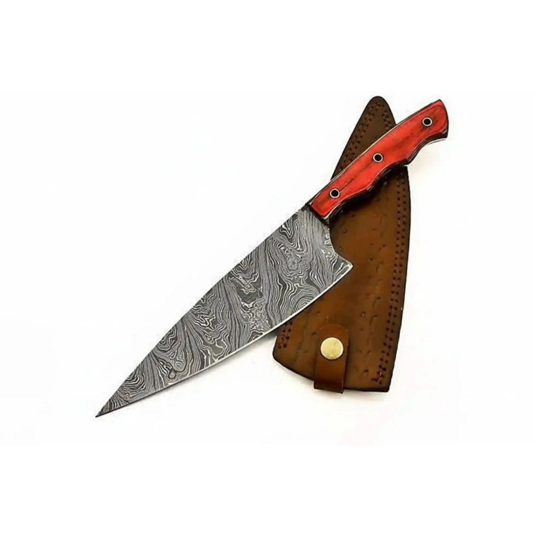 Wide Damascus kitchen knife featuring a red handle and protective brown sheath