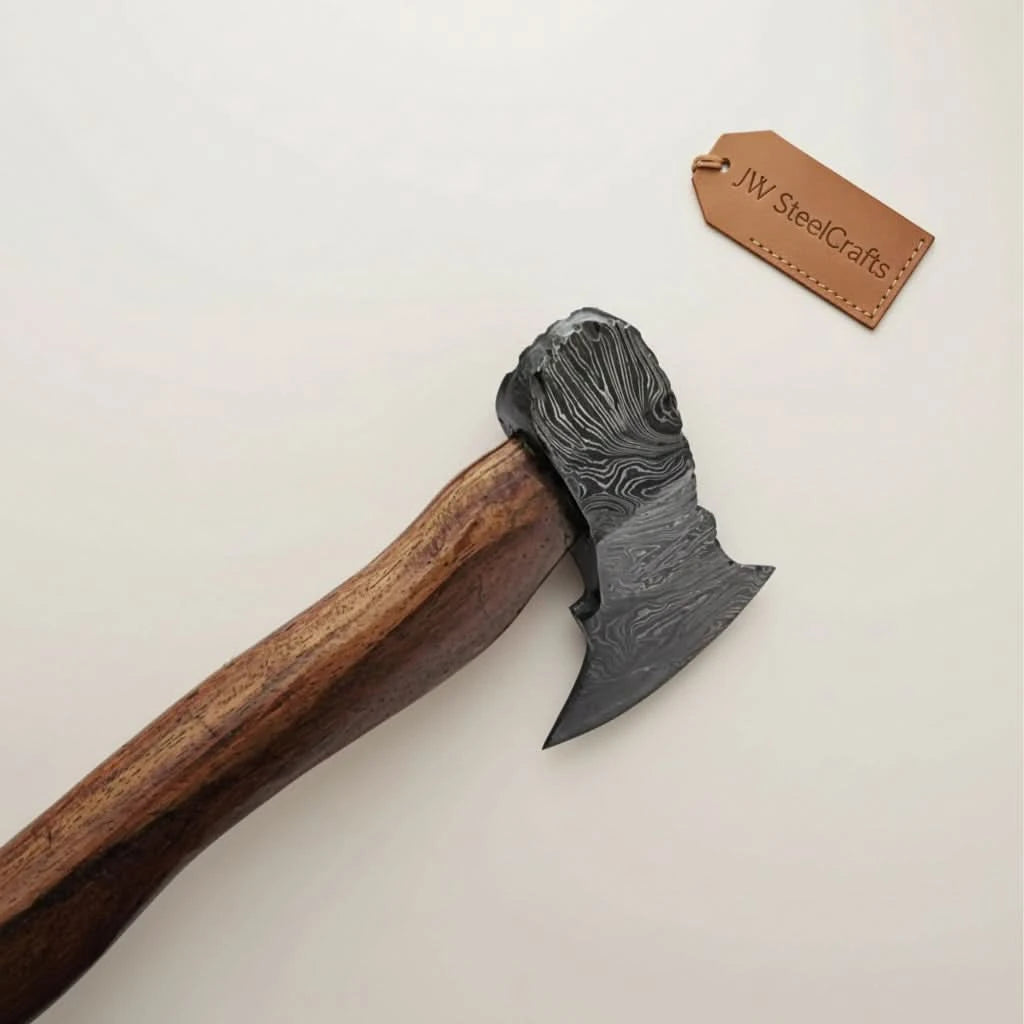 Thornforge-inspired Nordic Damascus hand axe with etched steel wave patterns and rustic forest presentation.