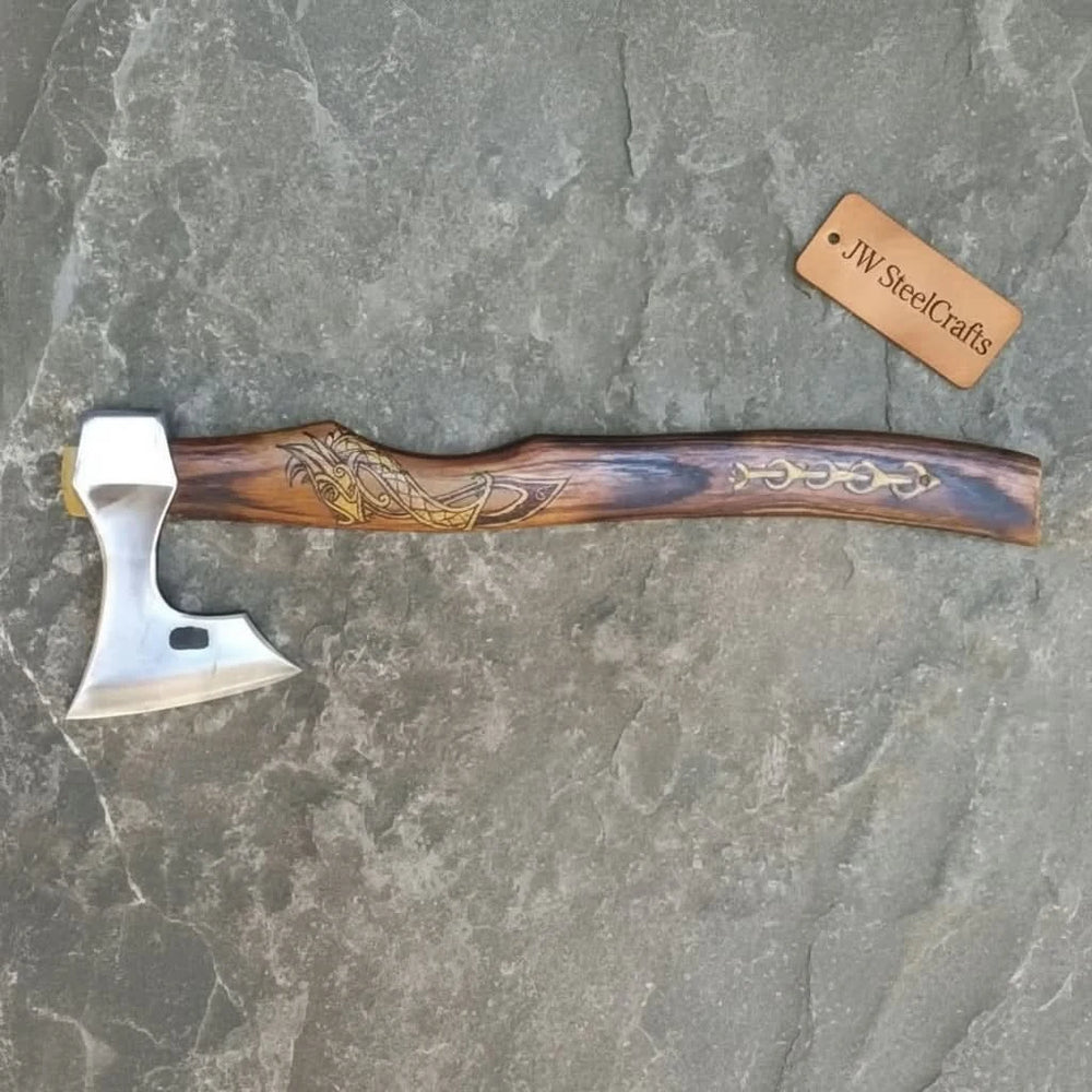     Traditional Norse-inspired axe with engraved Viking skull detail on the wooden handle and polished steel cutting edge.