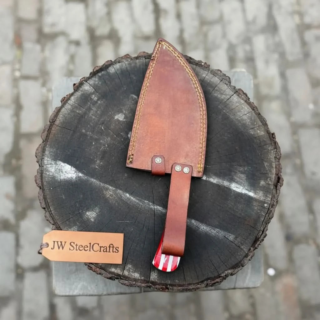Leather sheath American flag cleaver displayed on rough wood with JW SteelCrafts branding