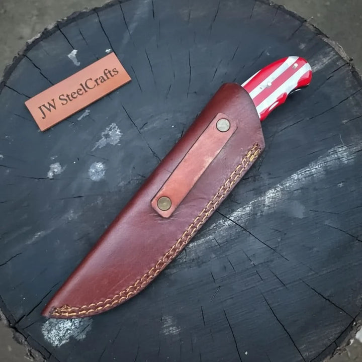 Stitched sheath custom patriotic knife with a red striped handle partially visible from the leather cover.
