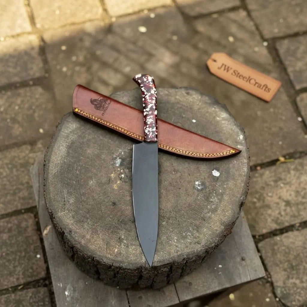 Brown leather sheath behind a black blade chef knife with patterned resin handle