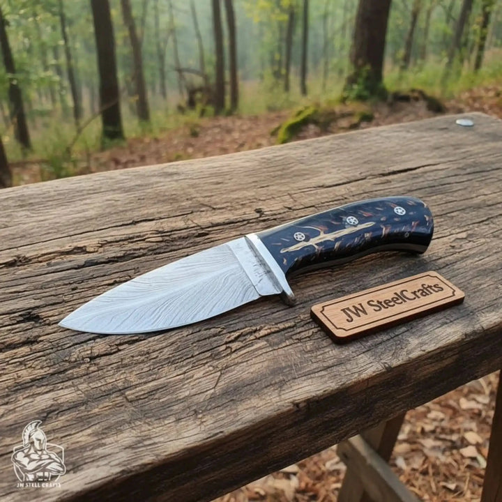 fixed blade knife with black resin grip, Damascus blade, silver bolster, mosaic pins, and JW SteelCrafts wooden label.