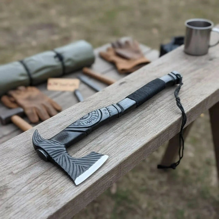 Thornveil-themed Nordic combat tool featuring engraved tactical hatchet and rugged outdoor accessories on timber.