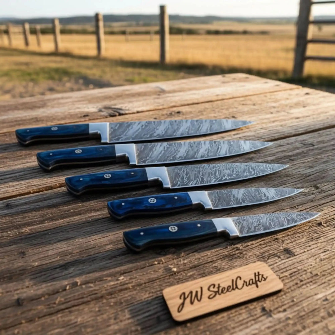 Handcrafted Damascus kitchen knives with decorative blade textures and polished blue grips.
