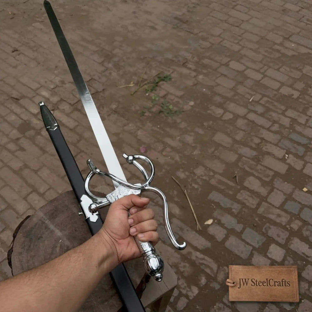 Close-up of a person holding a decorative silver rapier with an elaborate swept basket guard and engraved crossguard