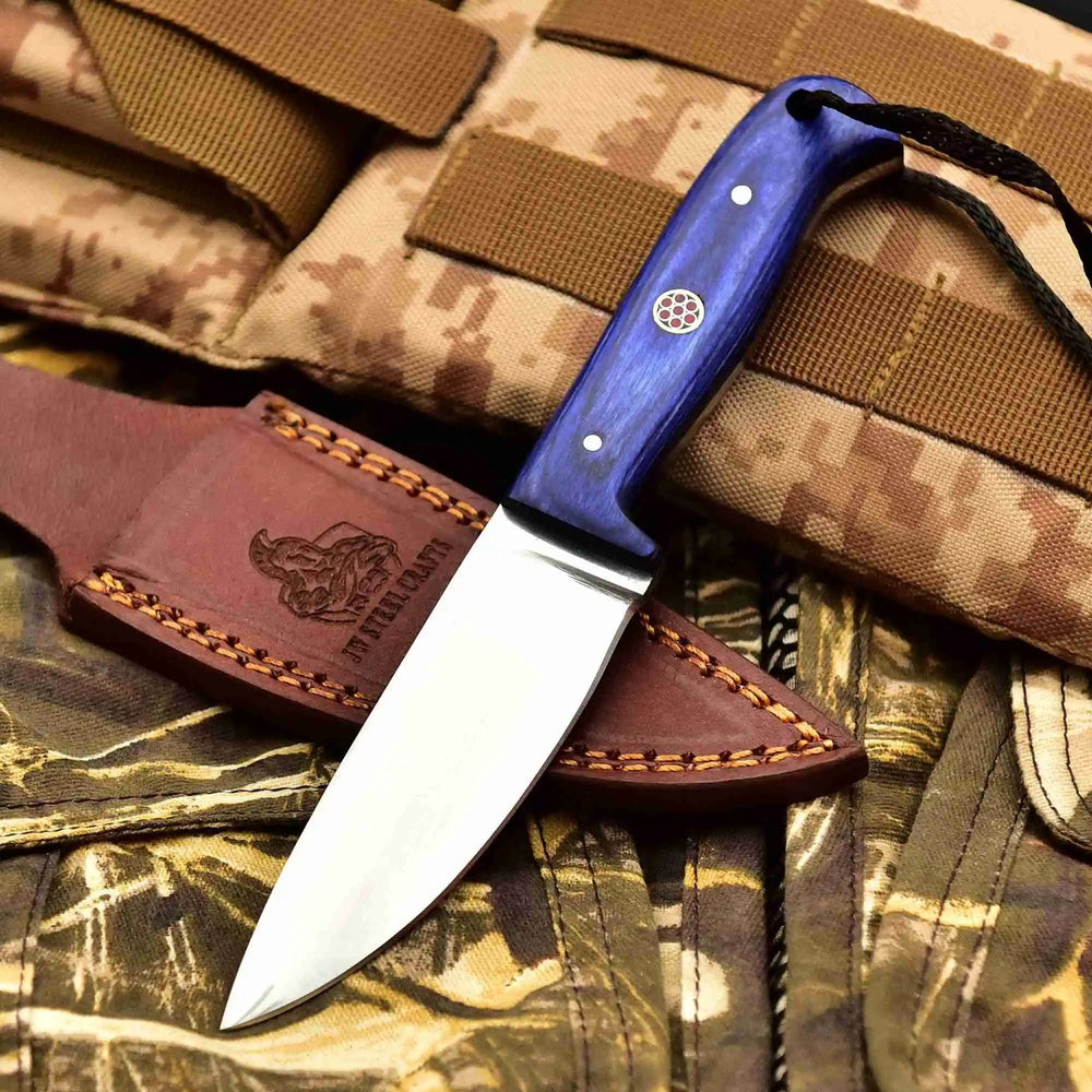 Bushcraft knife trio with pink, black, and blue handles, black braided lanyards, and stitched brown leather sheaths.