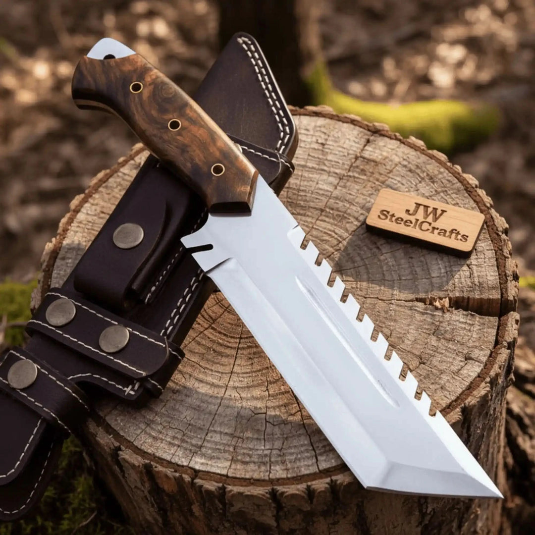 Large fixed blade survival knife displayed on a cut tree stump with leather sheath and JW SteelCrafts wooden label.