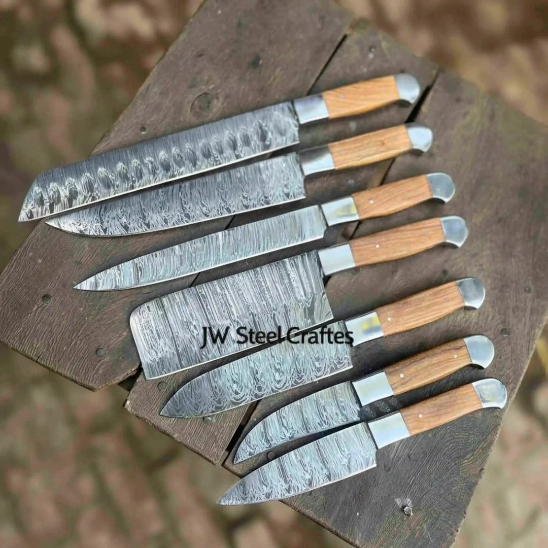 Birds eye view of Damascus steel kitchen knife set arranged neatly on rustic wooden table
