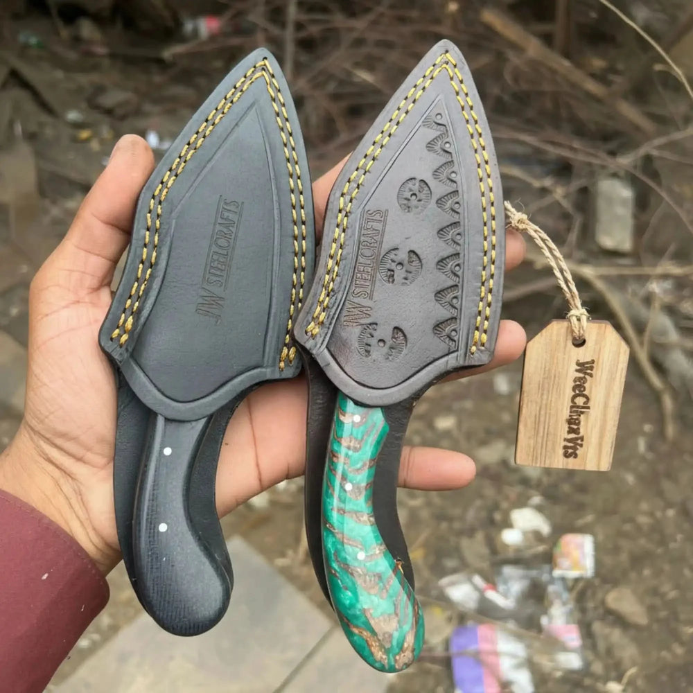 Tracker axe skinner knife set featuring two leather sheaths and a green handle held by a hand against a blurred background