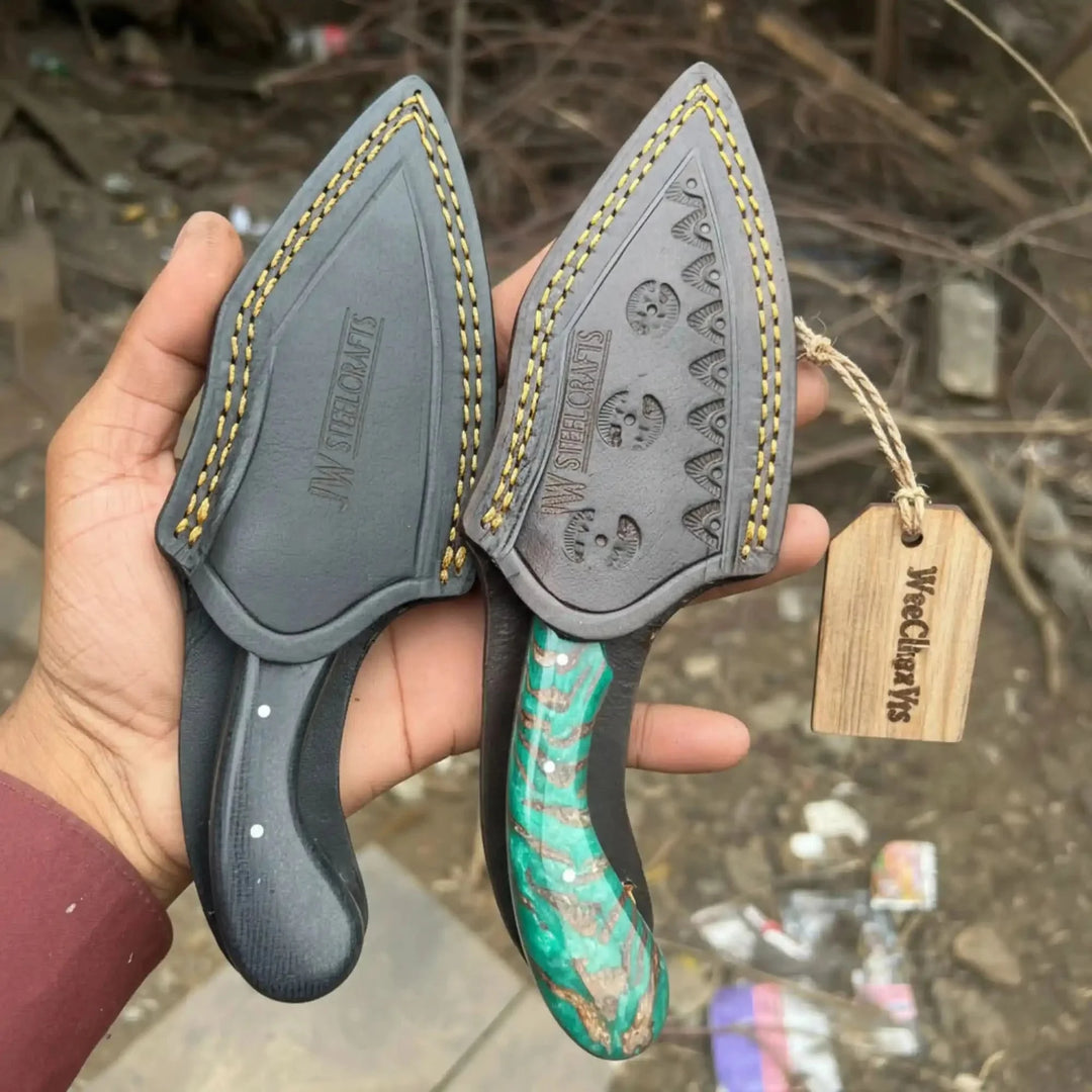 Tracker axe skinner knife set featuring two leather sheaths and a green handle held by a hand against a blurred background