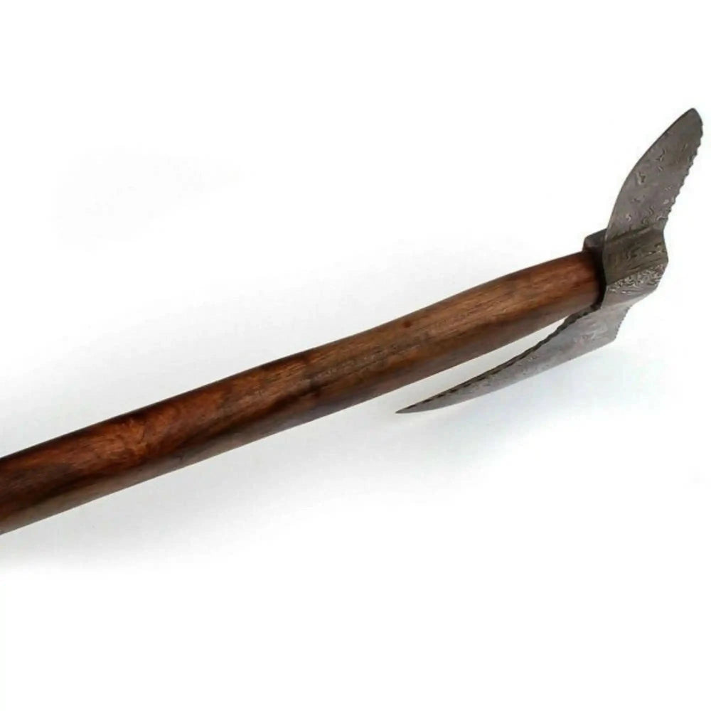     Artisan-made outdoor axe with detailed Damascus steel craftsmanship resting on a weathered wooden table beside camping gear