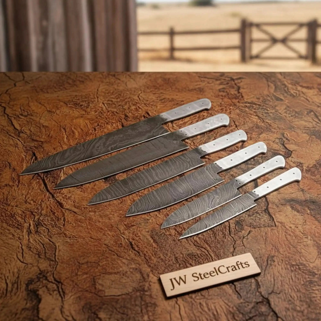 Raw Damascus chef knife set with exposed metal tangs and drilled handle holes