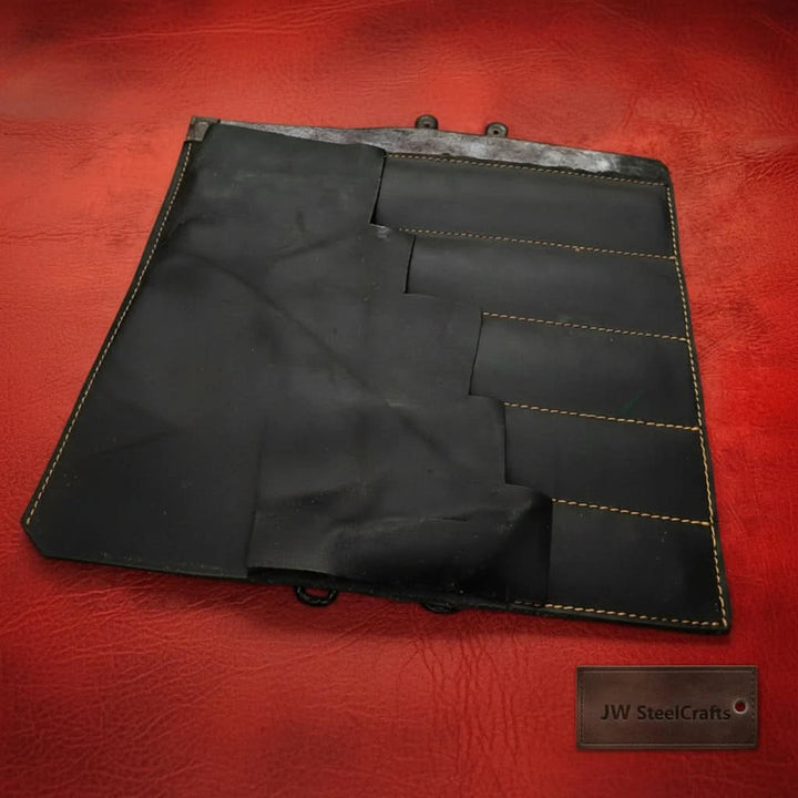 Black leather chef equipment case opened fully to display interior knife slots.