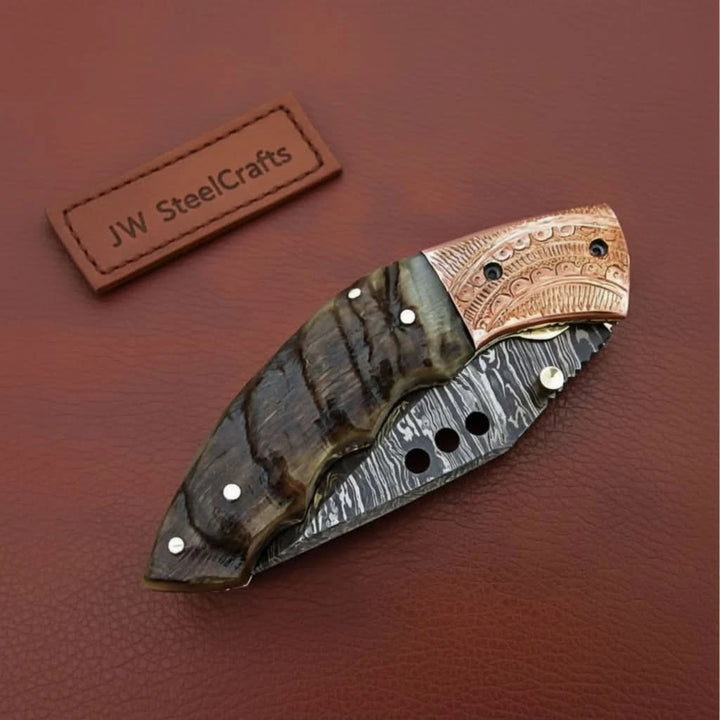     Bold Damascus pocket knife styled with rugged wood scales and decorative layered steel blade