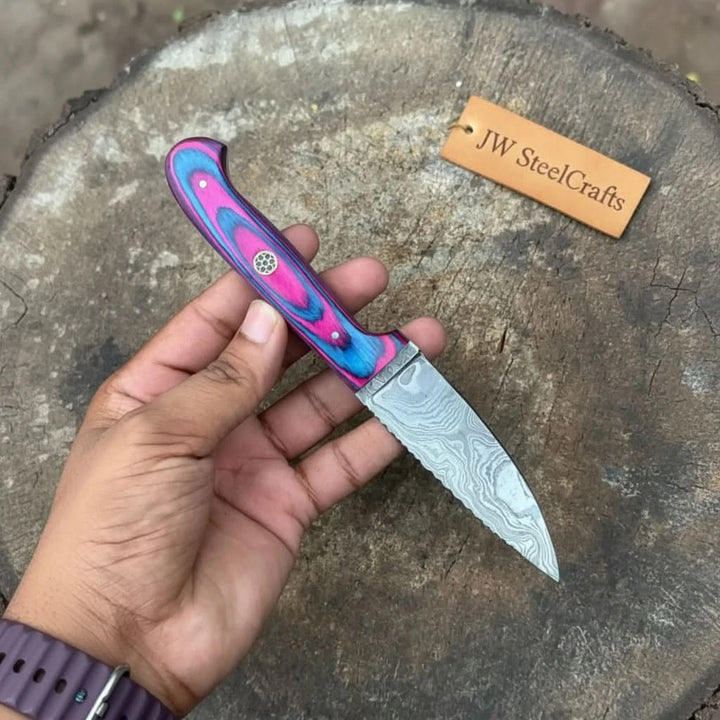 Pink blue grip custom small knife featuring a patterned Damascus blade and decorative handle pin.