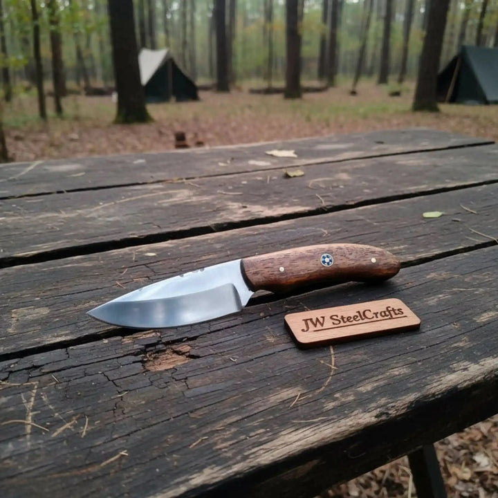 Custom hunting knife with polished blade, wooden grip, mosaic pin, and JW SteelCrafts wooden label on weathered wood.