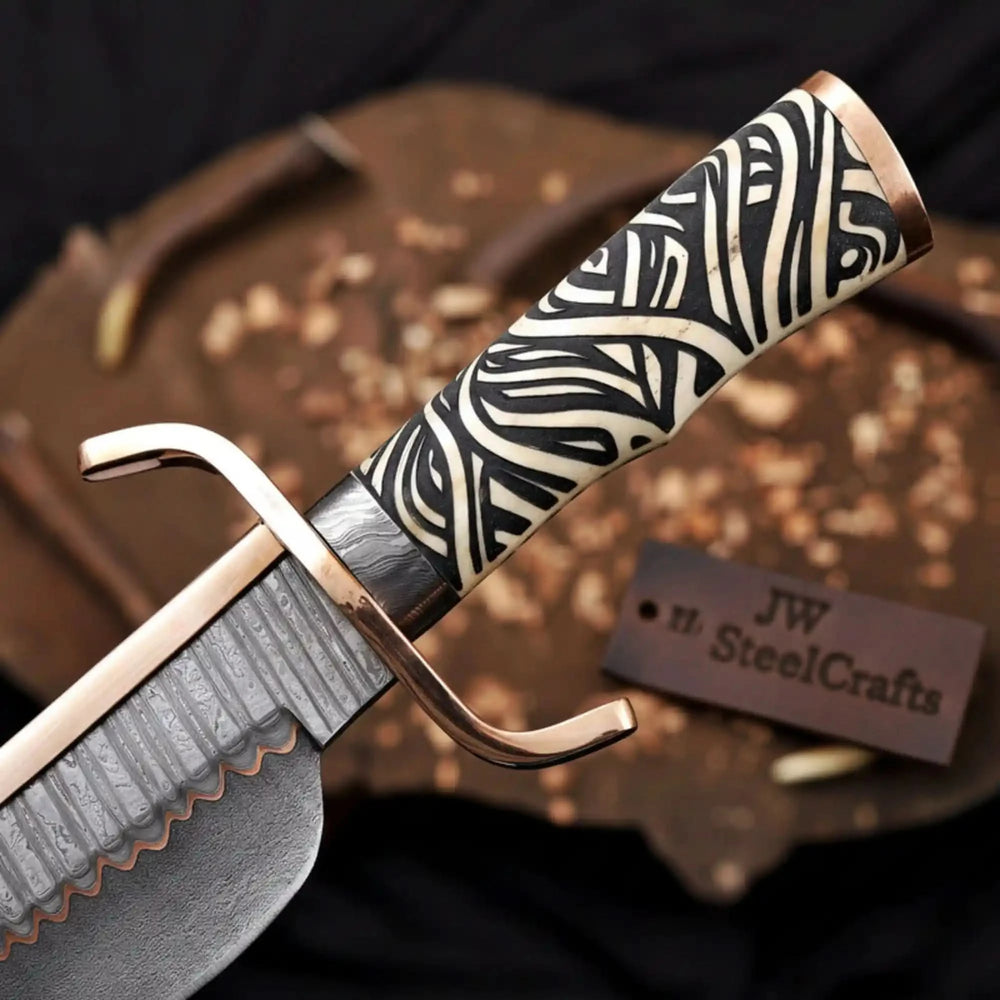 Luxury bowie knife with a zebra bone handle, curved copper guard, and premium orange crocodile leather sheath on a dark wood slab