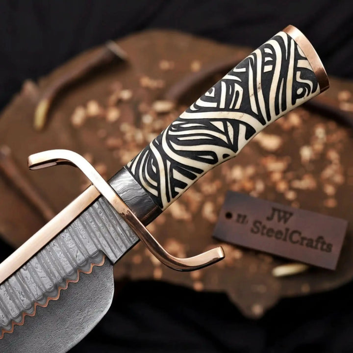 Luxury bowie knife with a zebra bone handle, curved copper guard, and premium orange crocodile leather sheath on a dark wood slab