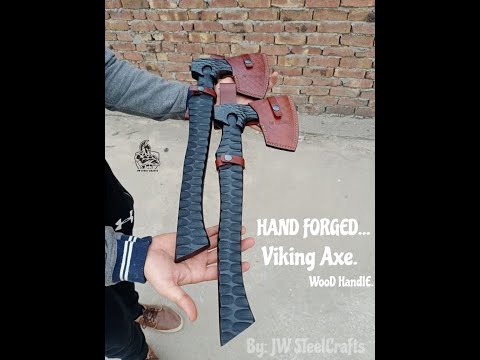Ardenforge-inspired crossed forged axes video featuring textured black steel heads and sculpted handles displayed on forest logs and stone.